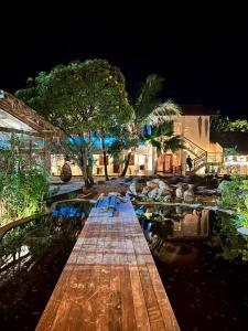 drewniany most nad stawem w nocy w obiekcie Villa Pantai Boutique Hotel Atins w mieście Atins