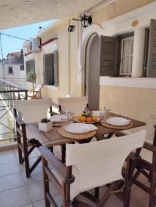 a wooden table and chairs on a balcony at Feidiou 1 in Egina