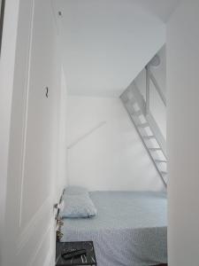 a white room with a bed and a staircase at Chambre familiale in Cachan +1 photo