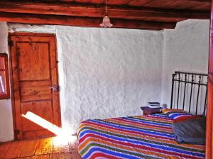 1 dormitorio con 1 cama y puerta abierta en Ca la Roia, en Taüll