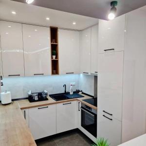 a white kitchen with white cabinets and a sink at Apartman BOSS Lux in Trebinje