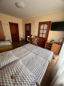 a bedroom with a bed and a table with chairs at Willa Balticus in Władysławowo