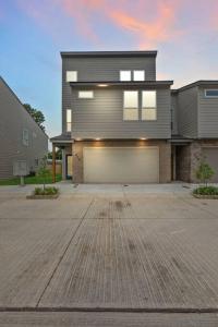 a large house with a garage in a driveway at Lagniappe House Cajun Country Gem King Bed in Lafayette