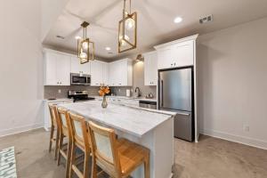 a kitchen with a large white counter and a refrigerator at Lagniappe House Cajun Country Gem King Bed in Lafayette