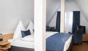 two pictures of a bedroom with a bed with blue sheets at Hotel Restaurant Wolfsschlucht GmbH in Bad Münstereifel