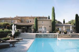 a house with a swimming pool in front of a house at La Verrière in Crestet