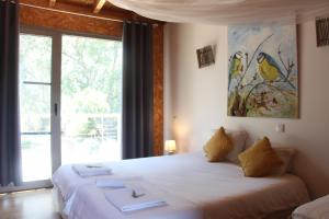 a bedroom with a white bed with a window at Biovilla Sustentabilidade in Palmela