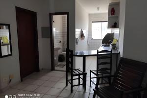 a kitchen with a table and chairs and a bathroom at AP 04 DO CANTINHO DO SOSSEGO in Dourados