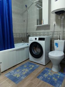 a washing machine in a bathroom with a toilet at 2-комнатная Комфорт на Сабитовой in Balqash