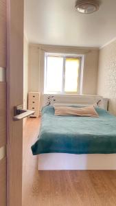 a bedroom with a large bed and a window at 2-комнатная Комфорт на Сабитовой in Balqash