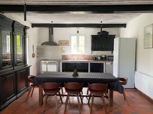 a kitchen with a table and chairs and a refrigerator at Calme Normand in Saint-Martin-Plage