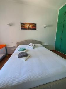 a white bed with a towel on top of it at Stella Marina Apartment in Fregene