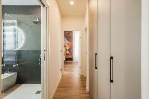 a hallway with a bathroom with a tub and a sink at 6 Isonzo - Luxury Stay Verona in Verona