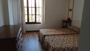 a hotel room with a bed and a desk and a window at Apartamentos Jasmund - Bungalow 119 in San Fernando