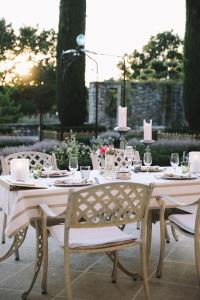 a table with a white tablecloth and chairs around it at La Verrière in Crestet