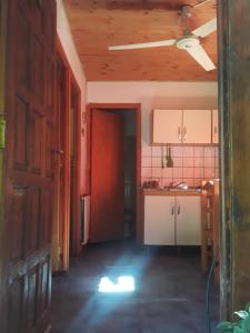 une cuisine vide avec une porte rouge dans une pièce dans l'établissement Cabañas La Fiaca, à Los Manantiales