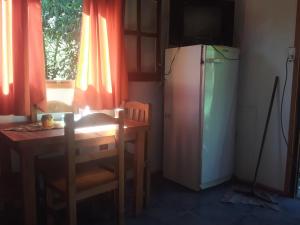 Il comprend une cuisine équipée d'une petite table et d'un réfrigérateur. dans l'établissement Cabañas La Fiaca, à Los Manantiales