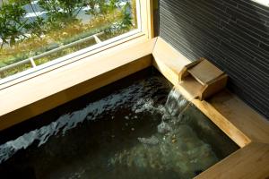 a koi pond in front of a window at 間人温泉 炭平 in Kyotango