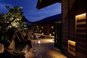 a building at night with a tree and rocks at 間人温泉 炭平 in Kyotango