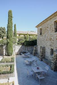a patio with tables and chairs in front of a building at La Verrière in Crestet