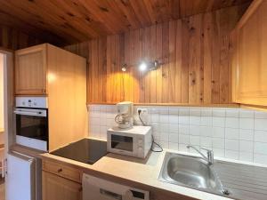 a kitchen with a sink and a microwave at Studio confortable au centre de Méribel, proche pistes et commerces, parfait pour 4 personnes - FR-1-180-4 in Méribel +13 photos