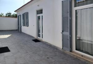 a white building with a door and a patio at Holiday Homes Villetta Blu in Nettuno