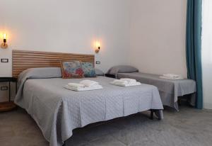 een slaapkamer met twee bedden met handdoeken erop bij Holiday Homes Villetta Blu in Nettuno