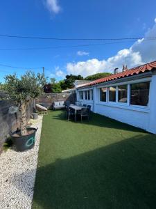 une terrasse avec une table et des chaises ainsi qu'une maison dans l'établissement Lodge des pins au coeur de la forêt d'Olonne, à Olonne-sur-Mer