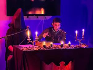 a man is sitting at a table with candles at Black Star Art Hostel in Neuquén