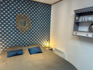 une chambre avec un lit avec un miroir au mur dans l'établissement Lodge des pins au coeur de la forêt d'Olonne, à Olonne-sur-Mer