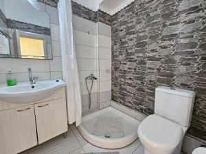 a bathroom with a sink and a toilet and a shower at Leta apartments in Agios Georgios +114 photos