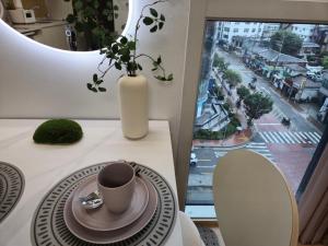 - une table avec une tasse de café et un vase dans l'établissement Sunshine house, à Séoul 23 autres photos