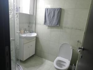 a white bathroom with a toilet and a sink at Casa del Mar in Eforie Nord