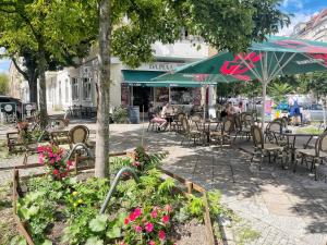 an outdoor cafe with tables and chairs and flowers at Apartment Prenzlauer Berg in Berlin