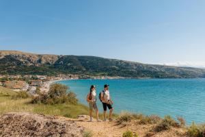 two people standing on a hill overlooking a body of water at Hotel Dobrovit in Baška