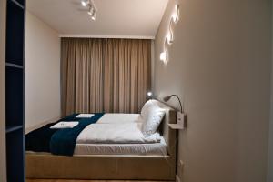 a bedroom with a bed and lights on the wall at Laguna Beskidów Resort - Apartament Widokowa Przystań in Zarzecze