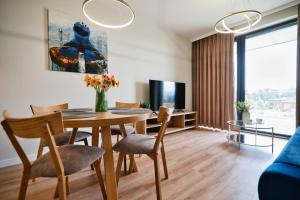 a living room with a table and chairs and a tv at Laguna Beskidów Resort - Apartament Widokowa Przystań in Zarzecze