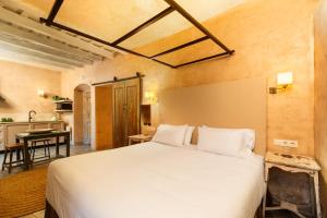 een slaapkamer met een groot bed en een keuken bij Hotel Boutique V in Vejer de la Frontera