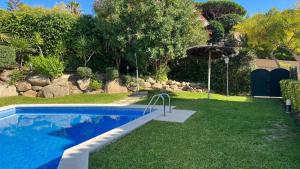 a swimming pool in a yard next to a garden at Casa Adosada S'Agaró in S'agaro