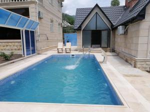 a swimming pool in the backyard of a house at Viva hotel Gabala with outdoor pool ,Sauna and Waterfall in Gabala