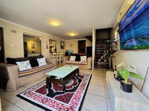 a living room with a couch and a table at Walters Lane Deluxe Garden Apartment 3 - No loadshedding in Cape Town
