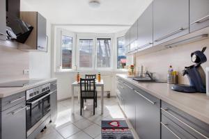 een keuken met witte kasten en een tafel. bij Haus Castellbergblick mit Balkon in Ballrechten