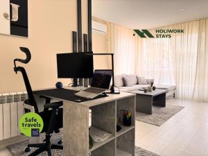 an office with a desk with a laptop computer on it at Elite Business Residence with Free Gym Pass, Street Parking and Full Office Setup in Plovdiv +31 photos
