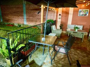 Un patio con una mesa y sillas y una sombrilla. en Lindo dpto con vista al jardin, internet y cable, en Lima