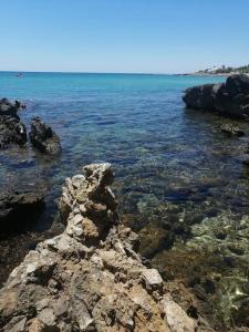a body of water with rocks in the water at Apprt Proche Plage - Bien equipé in Kelibia