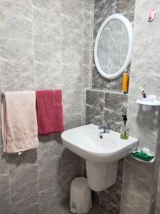 a bathroom with a sink and a mirror and towels at Apprt Proche Plage - Bien equipé in Kelibia