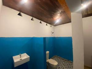 a blue bathroom with a toilet and a sink at Diki Bungalows in Kuta Lombok