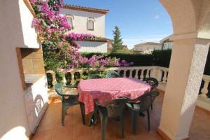 una mesa y sillas en un balcón con flores en ARENDA Pino Alto Holiday Home Masia 1, en Miami Platja