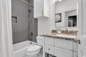 a white bathroom with a toilet and a sink at Whiskey River - Texas Music Theme in Historic Gruene, Riverfront on the Guadelupe River in New Braunfels +34 photos
