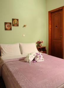 Una cama rosa con un animal de peluche encima. en Chrysoula's Guests en Ioánina